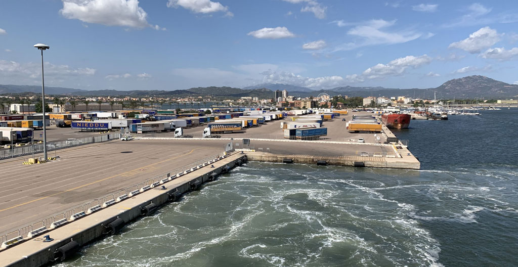 Couple de vacanciers étudiant une carte de Sardaigne pour planifier leur itinéraire depuis le port de débarquement